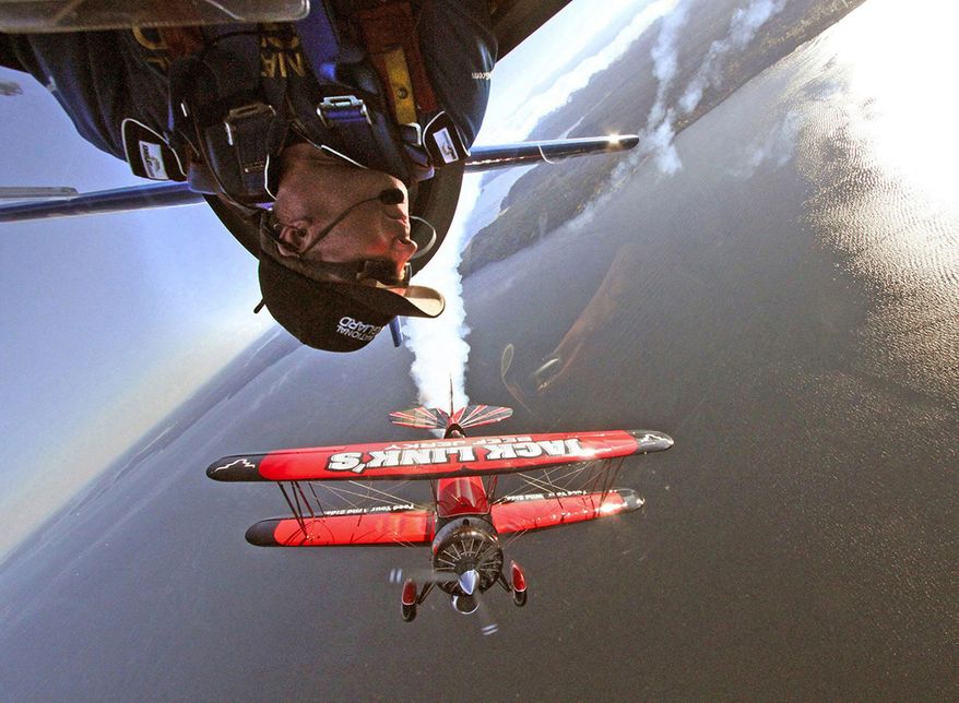 In this July 24, 2014 photo, which is the winner of the Reid Blackburn Memorial Award in the 2015 AP Northwest Photo Contest, Air National Guard aerobatic pilot Lt. Col. John Klatt, top, flies upside down over Elliott Bay, near Seattle as aerobatic pilot Jeff Boerboon, flies in formation below him. The pair were preparing for a performance at the annual Seafair Air Show. (Greg Gilbert/The Seattle Times via AP) SEATTLE OUT; USA TODAY OUT; MAGS OUT; TELEVISION OUT; NO SALES; MANDATORY CREDIT TO BOTH THE SEATTLE TIMES AND THE PHOTOGRAPHER