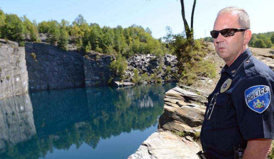 ADVANCE FOR SATURDAY, SEPT. 19, 2015, - In this photo taken Tuesday, Aug. 25, 2015, Bangor, Pa., Police Chief Scott Felchock gives a tour of a Bangor quarry known as Seven Slopes of Slate quarry, where people frequently attempt to swim and 19 people were cited for trespassing the previous weekend. Although divers flock to a cliff about 120 feet above the water, water temperatures below the quarry's surface vary dramatically even in midsummer, posing risks of "cold shock," hypothermia and drowning as temperatures dip from the 70s at the surface to the 50s just 15 feet below. (Emily Paine/The Morning Call via AP) THE EXPRESS-TIMES OUT; WFMZ OUT; MANDATORY CREDIT