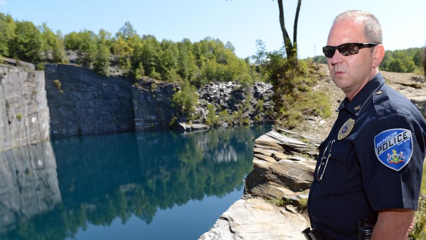 ADVANCE FOR SATURDAY, SEPT. 19, 2015, - In this photo taken Tuesday, Aug. 25, 2015, Bangor, Pa., Police Chief Scott Felchock gives a tour of a Bangor quarry known as Seven Slopes of Slate quarry, where people frequently attempt to swim and 19 people were cited for trespassing the previous weekend. Although divers flock to a cliff about 120 feet above the water, water temperatures below the quarry's surface vary dramatically even in midsummer, posing risks of "cold shock," hypothermia and drowning as temperatures dip from the 70s at the surface to the 50s just 15 feet below. (Emily Paine/The Morning Call via AP) THE EXPRESS-TIMES OUT; WFMZ OUT; MANDATORY CREDIT