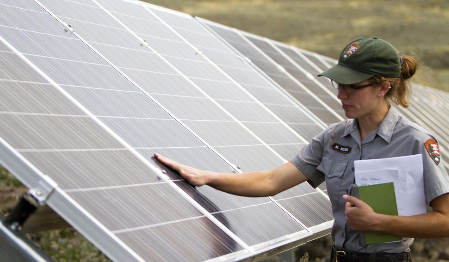 In this Thursday, Aug. 27, 2015 photo, Molly Nelson talks about a solar power array that is part of sustainability improvements at the Lamar Buffalo Ranch in Yellowstone National Park, Wyo. (Ryan Jones/Jackson Hole News&Guide via AP)