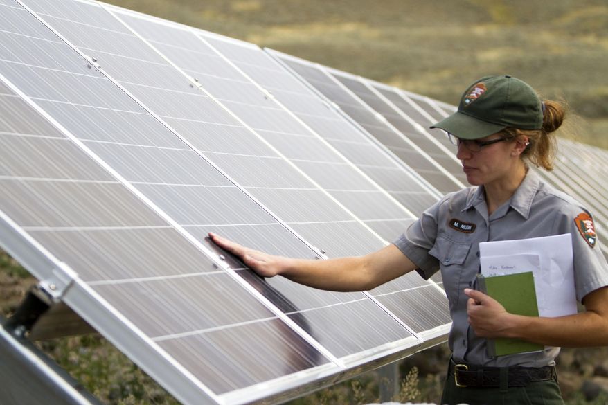In this Thursday, Aug. 27, 2015 photo, Molly Nelson talks about a solar power array that is part of sustainability improvements at the Lamar Buffalo Ranch in Yellowstone National Park, Wyo. (Ryan Jones/Jackson Hole News&Guide via AP)