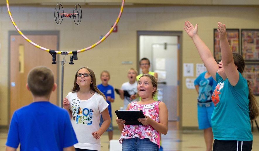 FOR RELEASE SATURDAY, SEPTEMBER 19, 2015, AT 12:01 A.M. CDT - In this Aug. 25 photo, fifth-grade students Kyla Paladino, Katherine Vandenberg and Sophie English react as their drone flies through a hula hoop during an experiment at Whitetail Elementary in Gretna, Neb. (Megan Farmer/Omaha World-Herald via AP) MAGS OUT; ALL NEBRASKA LOCAL BROADCAST TELEVISION OUT; MANDATORY CREDIT