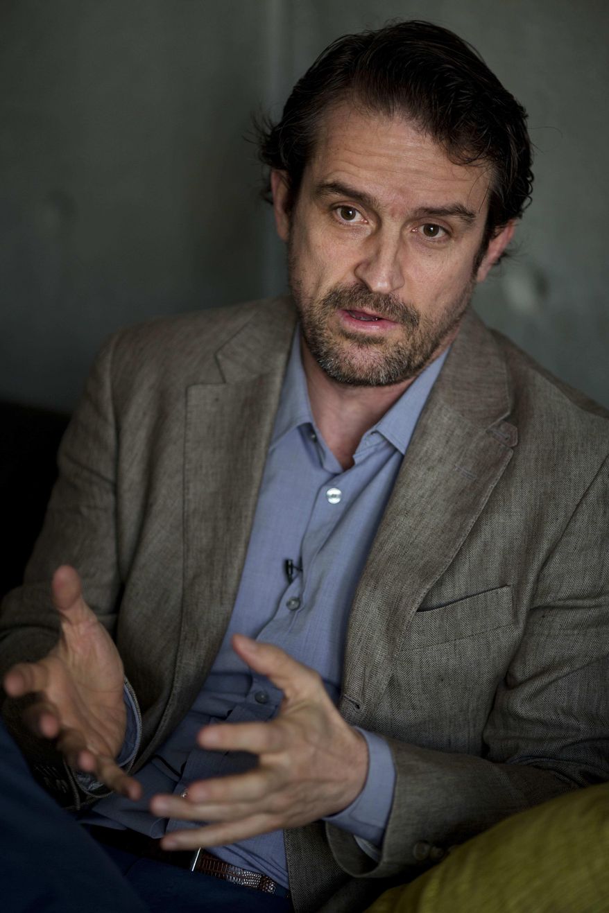 FILE - In this July 31, 2015 file photo, Venezuelan filmmaker Lorenzo Vigas gives an interview about his movie "From Afar" in his apartment in Caracas, Venezuela. The debut feature "From Afar," by the little-known Venezuelan director, won top honors at the Venice Film Festival, one of the industry's top events. The film is about an affair between a wealthy middle-aged man and a teenage thug set against a background of poverty and violence. (AP Photo/Ariana Cubillos, File)