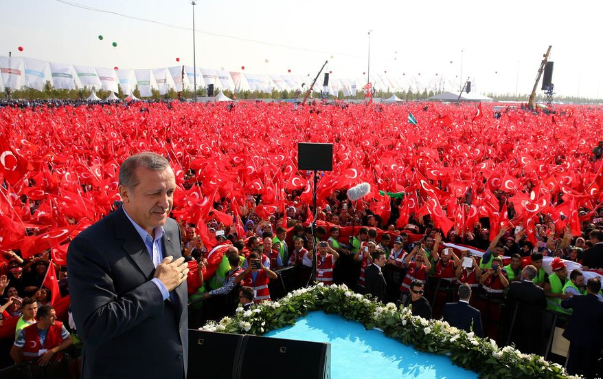 Turkey's President Recep Tayyip Erdogan salutes supporters as tens of thousands of flag-waving demonstrators rally to denounce violence by Kurdish rebels, in Istanbul, Turkey, Sunday, Sept. 20, 2015. Speakers condemned terrorism and the violence which has rocked eastern Turkey since the resumption of fighting between the military and the Kurdistan Workers' Party, or PKK. The separatist group is considered a terror organization by the Turkey, the U.S. and the EU.(Presidential Press Service/Pool photo via AP)