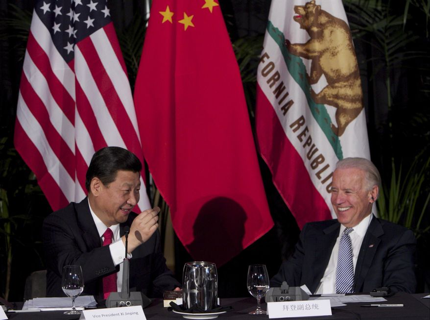 In this Feb. 17, 2012, file photo, Xi Jinping, China&#39;s president and Communist Party chief, left, eats Hawaiian macadamia chocolate gifted by Governor of Hawaii, Neil Abercrombie, not seen, during a governors meeting held inside the Walt Disney Concert Hall as then-Vice President Joe Biden, right, looks on in Los Angeles. (AP Photo/Damian Dovarganes, File)