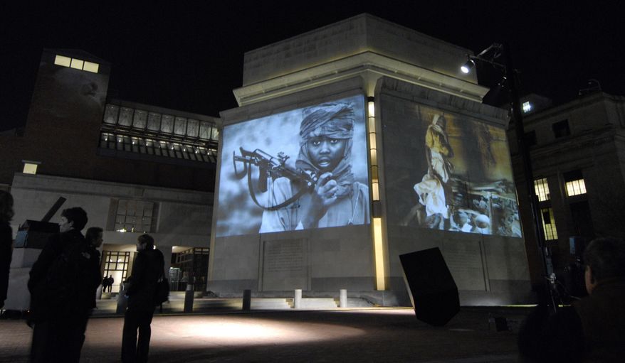 In this Monday, Nov. 20, 2006, file photo, images from Darfur and Chad are projected on the exterior walls of the United States Holocaust Memorial Museum in Washington. To try to predict and prevent mass killings, the museum is making both sophisticated statistical analysis and feedback from experts publicly available for the first time to produce early warnings that can help governments, policy makers, advocacy groups and scholars decide where to concentrate their efforts. The Early Warning Project online tool was announced Monday, Sept. 21, 2015. (AP Photo/Nick Wass)