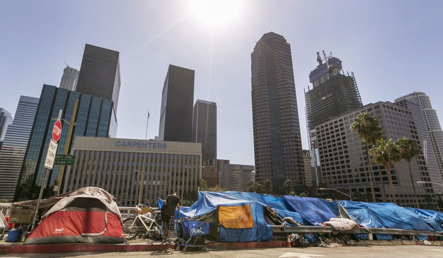 Tents used by the homeless line a downtown Los Angeles street with the skyline behind Tuesday, Sept. 22, 2015. Los Angeles officials say they will declare a state of emergency on homelessness and propose spending $100 million to reduce the number of people living on city streets. (AP Photo/Damian Dovarganes) ** FILE **