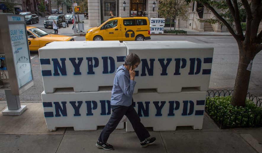 A pedestrian passes NYPD concrete barriers near the residence to the Vatican&#39;s ambassador to the United Nations, where Pope Francis is scheduled to stay, Tuesday, Sept. 22, 2015, in New York. (AP Photo/Bryan R. Smith) 