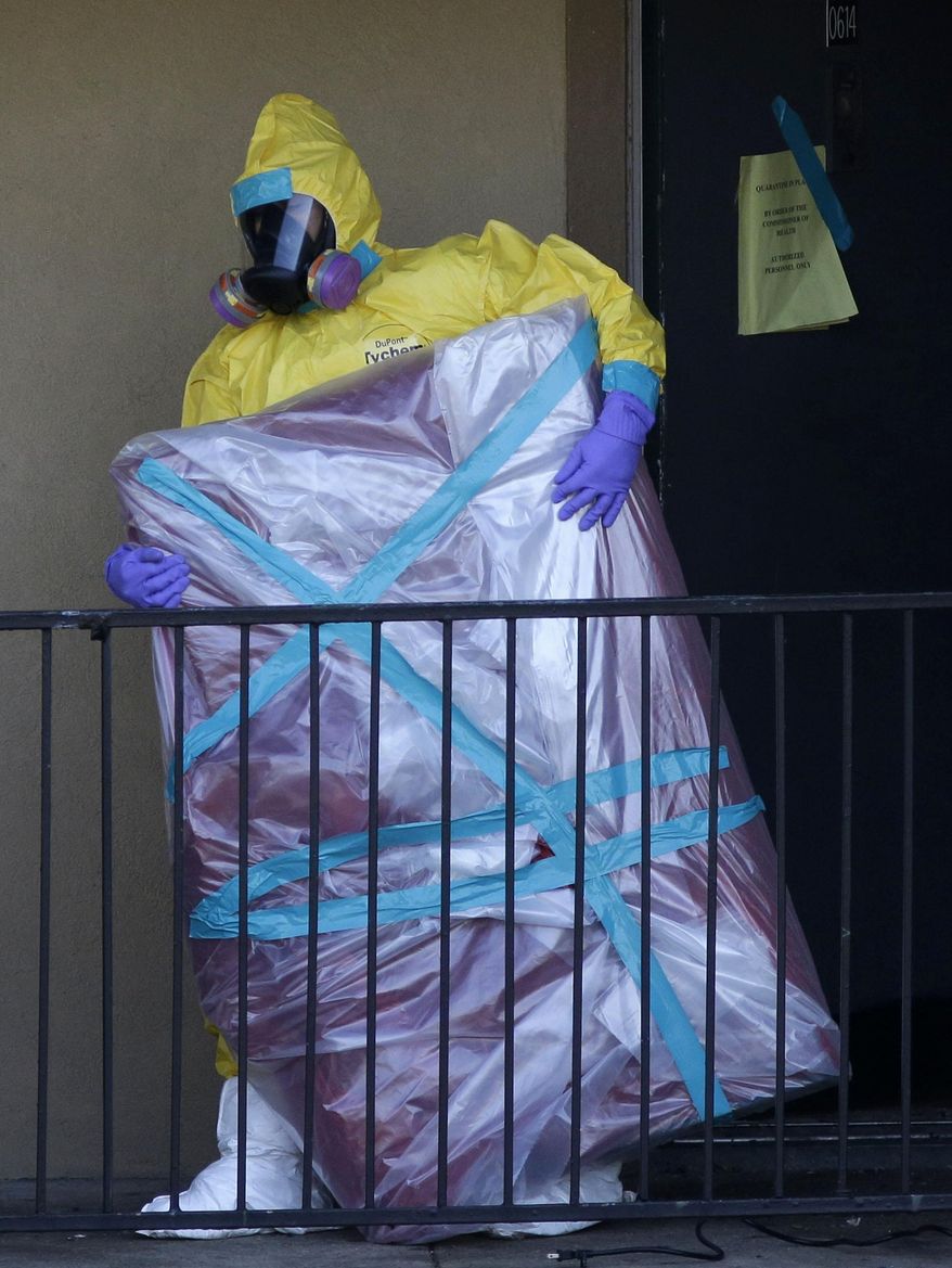 FILE - In this Oct. 6, 2014, file photo, a hazardous material cleaner removes a wrapped item from the Dallas apartment where Thomas Eric Duncan, the Ebola patient who traveled from Liberia to Dallas, stayed. Most people will experience at least one wrong or delayed diagnosis in their lifetime, concludes an alarming report that calls diagnostic errors a blind spot in modern medicine that can cause devastating consequences. (AP Photo/LM Otero, File)