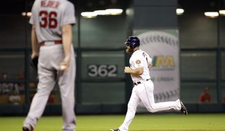Houston Astros&#39; Evan Gattis, right, runs the bases after hitting a two-run home run off Los Angeles Angels starting pitcher Jered Weaver (36) during the second inning of a baseball game Monday, Sept. 21, 2015, in Houston. Colby Rasmus scored on Gattis&#39; homer. (AP Photo/David J. Phillip)