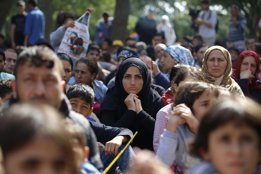 Migrants, mostly Syrians, listen to an Arabic speaker talk to them about their future as they rest in a stadium used for traditional Kirkpinar Oil Wrestling, while waiting to cross to Europe near Turkey’s western border with Greece and Bulgaria, in Edirne, Turkey, Wednesday, Sept. 23, 2015. Hundreds of migrants have made the trek to Edirne in the hope of being allowed to cross into neighboring Greece or Bulgaria and avoid the often-risky journey across the Aegean Sea. Many arrived last week but have been blocked from approaching the border by law enforcement.(AP Photo/Emrah Gurel)