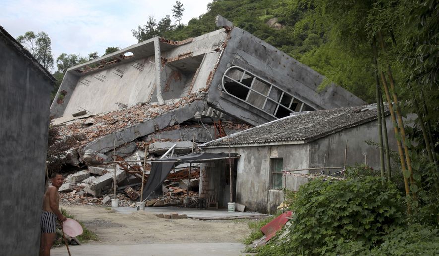 File- This July 16, 2014, file photo a man stands near the razed remains of a Catholic church in a village in Pingyang county of Wenzhou in eastern China's Zhejiang province. Since taking the presidency in 2013 and becoming the most powerful Chinese leader in three decades, President Xi Jinping has cracked down on encroachment of what he views as Western-style freedoms in China's increasingly prosperous and connected society. His administration has also tightened controls on religious minorities, including a government campaign to remove crosses and demolish Christian churches in an eastern province — a move that has drawn condemnation in the U.S. Congress. (AP Photo/Didi Tang, File)