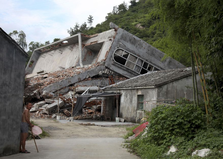 File- This July 16, 2014, file photo a man stands near the razed remains of a Catholic church in a village in Pingyang county of Wenzhou in eastern China's Zhejiang province. Since taking the presidency in 2013 and becoming the most powerful Chinese leader in three decades, President Xi Jinping has cracked down on encroachment of what he views as Western-style freedoms in China's increasingly prosperous and connected society. His administration has also tightened controls on religious minorities, including a government campaign to remove crosses and demolish Christian churches in an eastern province — a move that has drawn condemnation in the U.S. Congress. (AP Photo/Didi Tang, File)