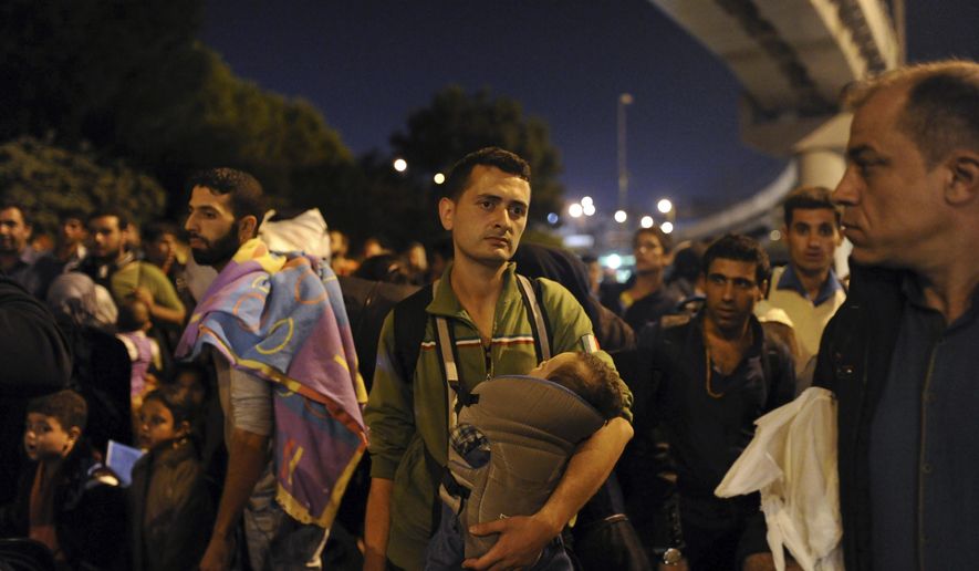Hundred of migrants, who were blocked at a bus station, walk down a highway towards Turkey’s western border with Greece and Bulgaria, early Monday morning, Sept. 21, 2015, in Istanbul, Turkey. Hundreds of migrants were stopped Friday by Turkish law enforcement on a highway near the city of Edirne, causing a massive traffic jam. (AP Photo/Omer Kuscu) **FILE**