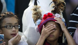 A school girl, who&#39;s parents work at the Philippine Embassy, adjusts her tradition head dress while her friend looks on outside the Apostolic Nunciature, the Vatican&#39;s diplomatic mission in the heart of Washington, as they wait for Pope Francis to depart en route to the Capitol to address a joint meeting of Congress Thursday, Sept. 24, 2015.  (AP Photo/Cliff Owen)