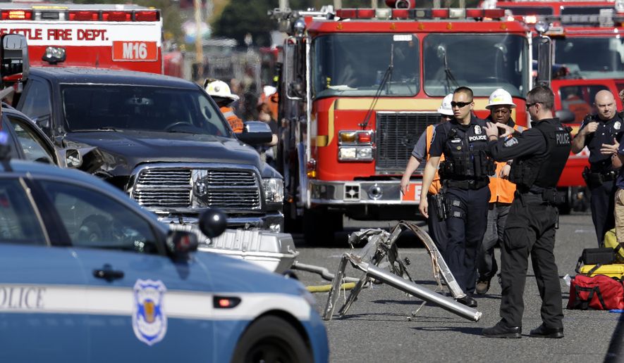 Emergency vehicles surround the site of a deadly crash between a charter bus and an amphibious tour vehicle in Seattle on Thursday, Sept. 24, 2015. Seattle fire officials say two people have been killed and numerous others critically injured in the crash that happened on a bridge over Lake Union. (AP Photo/Elaine Thompson)