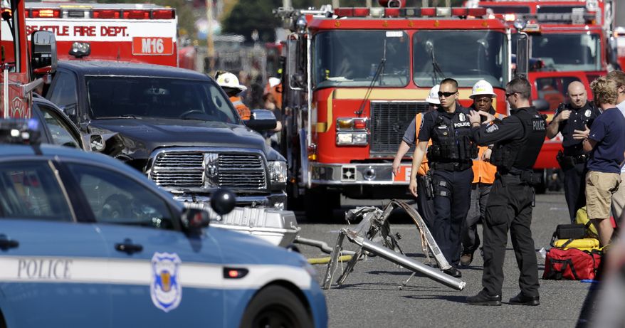 Emergency vehicles surround the site of a deadly crash between a charter bus and an amphibious tour vehicle in Seattle on Thursday, Sept. 24, 2015. Seattle fire officials say two people have been killed and numerous others critically injured in the crash that happened on a bridge over Lake Union. (AP Photo/Elaine Thompson)