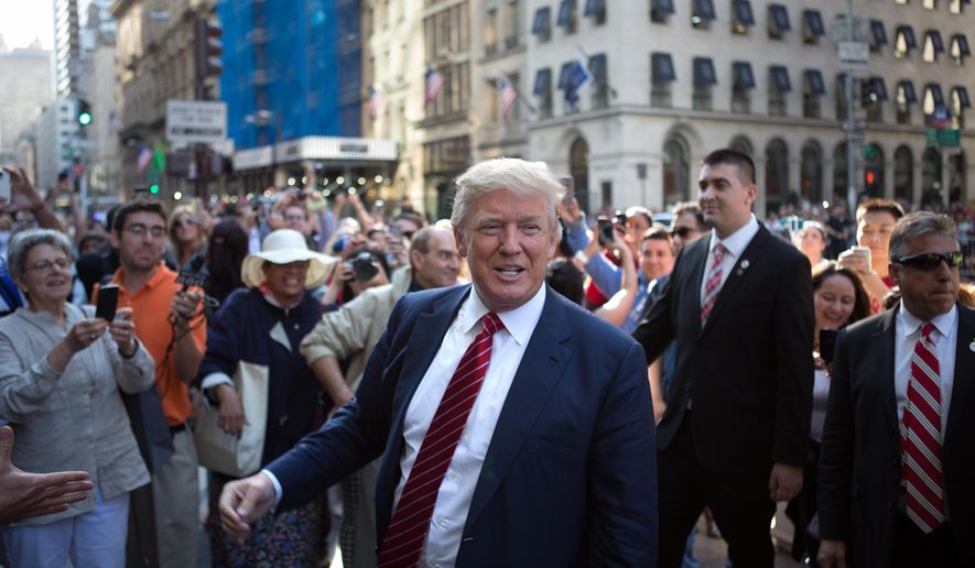 U.S. Presidential Candidate Donald Trump greets the crowd gathered in front of the Trump Tower ahead of the arrival of the pope&#39;s motorcade Thursday, Sept. 24, 2015, in New York.  (AP Photo/Kevin Hagen) ** FILE **