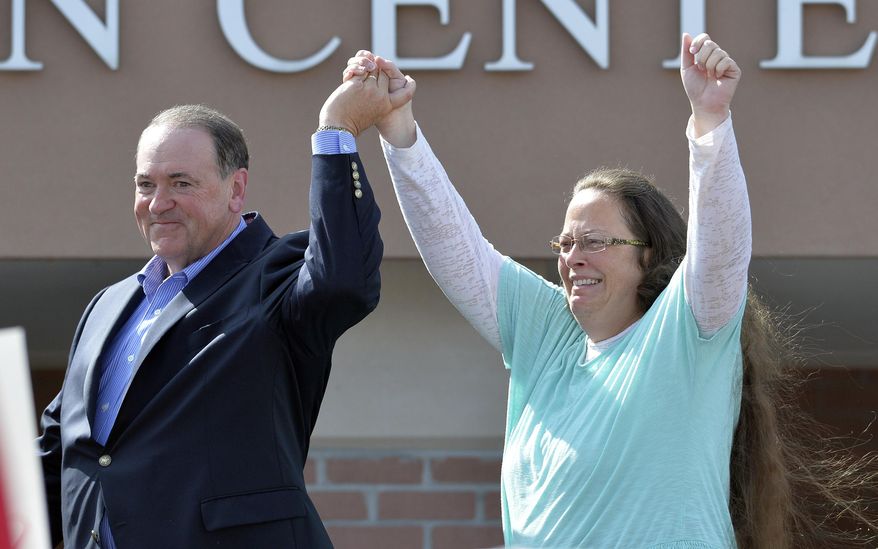 FILE - In this Sept. 8, 2015, file photo, Rowan County Clerk Kim Davis, with Republican presidential candidate Mike Huckabee at her side, greets the crowd after being released from the Carter County Detention Center, in Grayson, Ky. Davis, hauled to jail for defying a series of federal court orders and refusing to issue marriage licenses to same-sex couples, filed a 40-page court document Thursday, Sept. 24, blaming Kentucky governor Steve Beshear for all her legal woes. (AP Photo/Timothy D. Easley, File)
