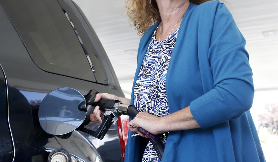Babette Davis fills the gas tank of her vehicle at a gas station in Sacramento, Calif., Thursday, Sept. 24, 2015. The California Air Resources Board is expected to decide, on Friday, to restore rules requiring a 10 precent cut in carbon emissions on fuels sold in the state, by 2020, despite oil industry objections that it could drive up gas prices. (AP Photo/Rich Pedroncelli)