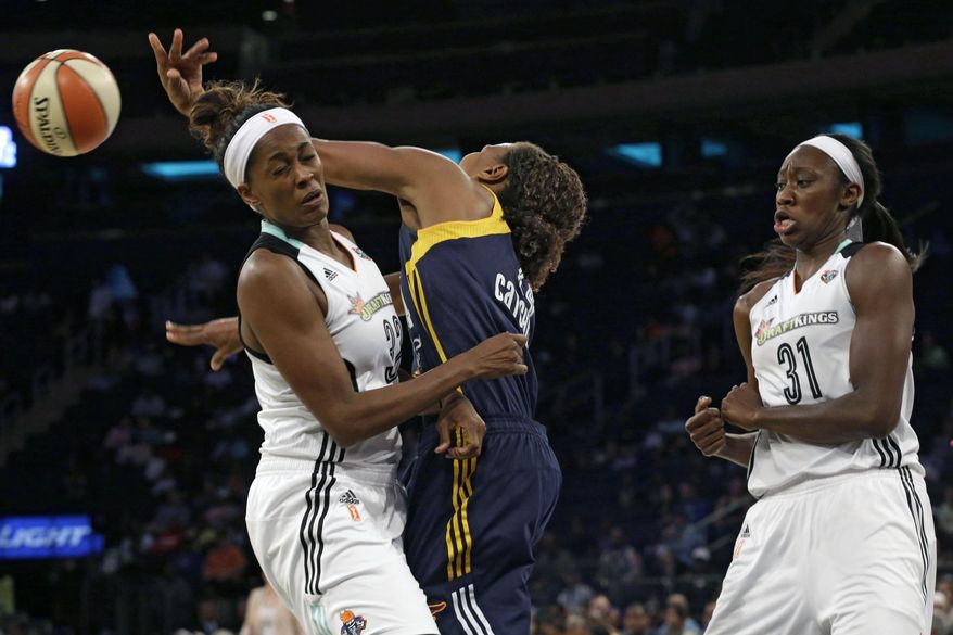 Indiana Fever forward Tamika Catchings, center, passes the ball past New York Liberty forward Swin Cash, left, and center Tina Charles during the first half of Game 1 of the WNBA basketball Eastern Conference finals, Wednesday, Sept. 23, 2015 at Madison Square Garden in New York. (AP Photo/Mary Altaffer)