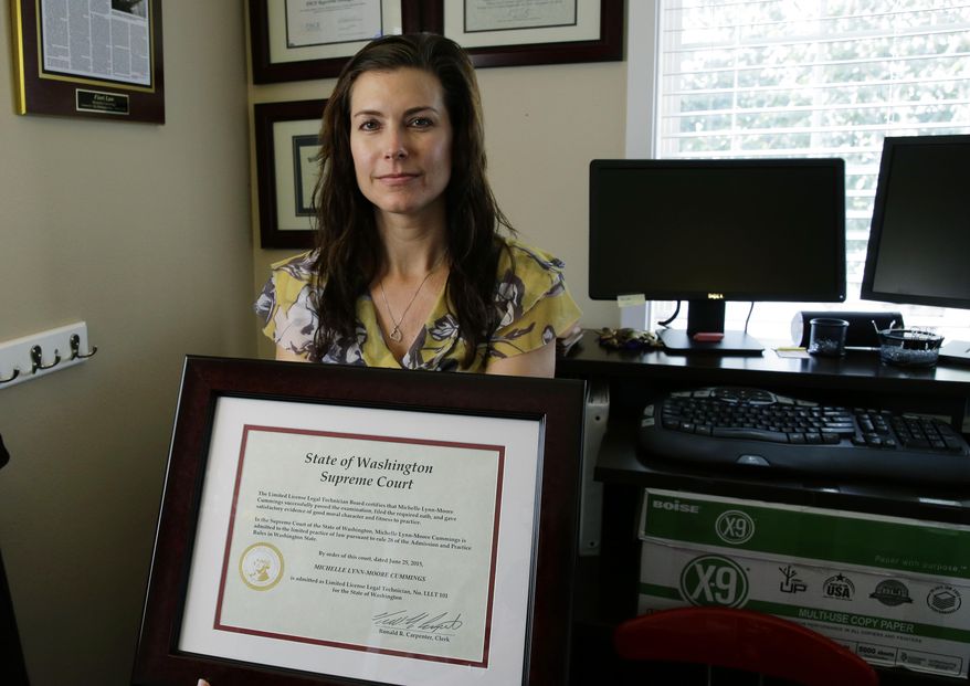 In this Aug. 12, 2015 photo, Michelle Cummings, the first limited license legal technician to be licensed in Washington state, poses for a photo in Auburn, Wash., with the certificate from the state Supreme Court that allows her to practice. The Court this year made Washington the first state to begin licensing non-lawyers to give legal advice, for a fraction of what lawyers often charge. (AP Photo/Ted S. Warren)