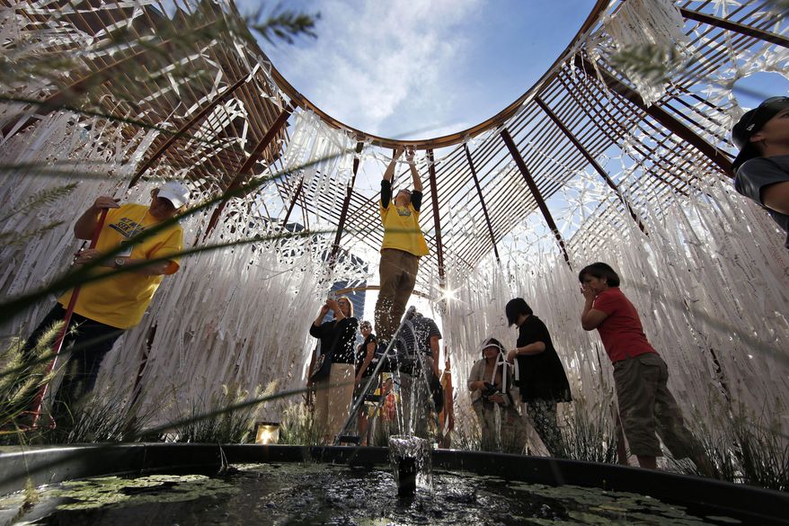 FILE - In this Thursday, Sept. 24, 2015, file photo, volunteer Luke Risher works on a ladder at the knotted grotto art project next to The Cathedral Basilica of Saints Peter and Paul in Philadelphia. Before leading a Mass on Sunday, Sept. 27, in the city, Pope Francis visited the art project, which includes messages gathered from local visitors and people around the world, written on strips of cloth before the strips were tied in knots. (AP Photo/Alex Brandon, File)