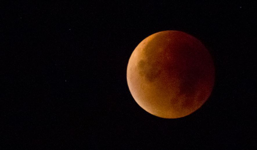 The Earth's shadow obscures the view of a so-called supermoon during a total lunar eclipse over Antwerp, Belgium, Monday, Sept. 28, 2015. Supermoon, or perigee moon, is the name given when the full or new moon comes closest to the Earth making it appear bigger. (AP Photo/Virginia Mayo)