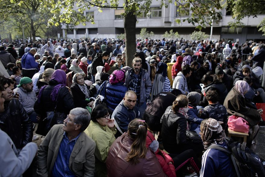 Hundreds of migrants and refugees wait for their registration at Berlin's central registration center for refugees and asylum seekers LaGeSo (Landesamt fuer Gesundheit und Soziales — State Office for Health and Social Affairs) in Berlin, Germany, Wednesday, Sept. 30, 2015. (AP Photo/Markus Schreiber)
