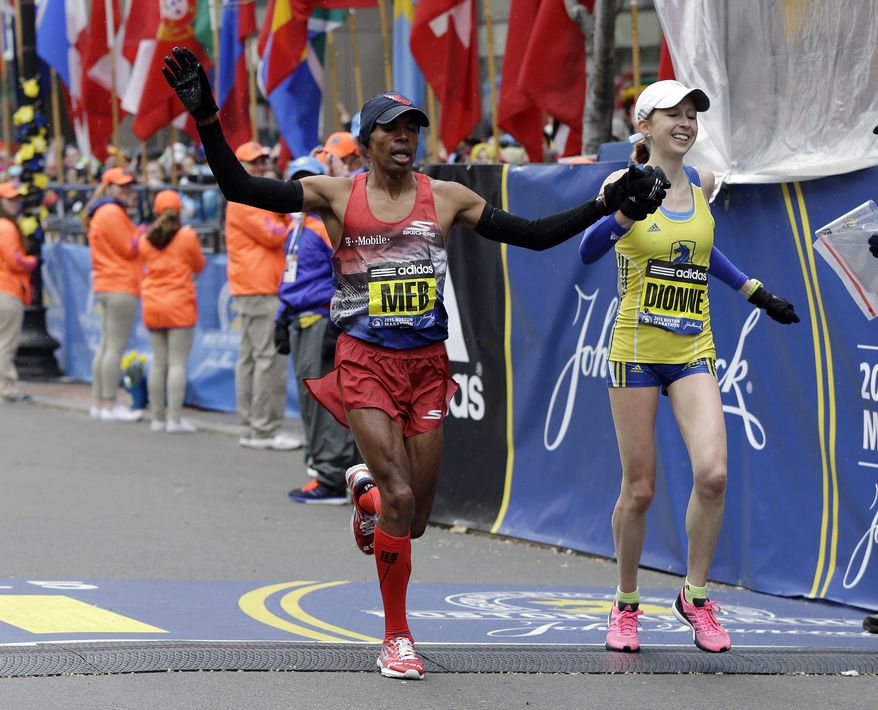 Meb Keflezighi, left, of San Diego, and Hilary Dionne, of Boston, finish the Boston Marathon Monday, April 20, 2015 in Boston. Keflezighi won the race in 2014. (AP Photo/Elise Amendola)