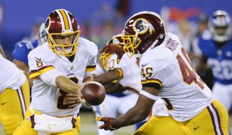 Washington Redskins quarterback Kirk Cousins (8) hands the ball to Alfred Morris (46) during the first half an NFL football game Thursday, Sept. 24, 2015, in East Rutherford, N.J. (AP Photo/Bill Kostroun)