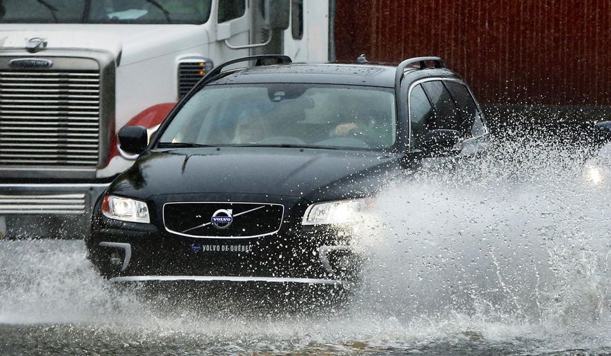 A motorist drives through flooding water in Portland, Maine, Wednesday, Sept. 30, 2015. Heavy rain has been moving through northern New England and a flood warning was issued for parts of Maine and New Hampshire. (AP Photo/Robert F. Bukaty)