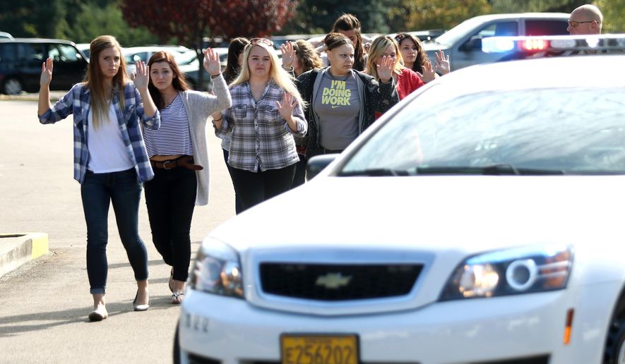 Students, staff and faculty are evacuated from Umpqua Community College in Roseburg, Ore. Thursday, Oct. 1, 2015, after a deadly shooting. (Michael Sullivan/The News-Review via AP) MANDATORY CREDIT