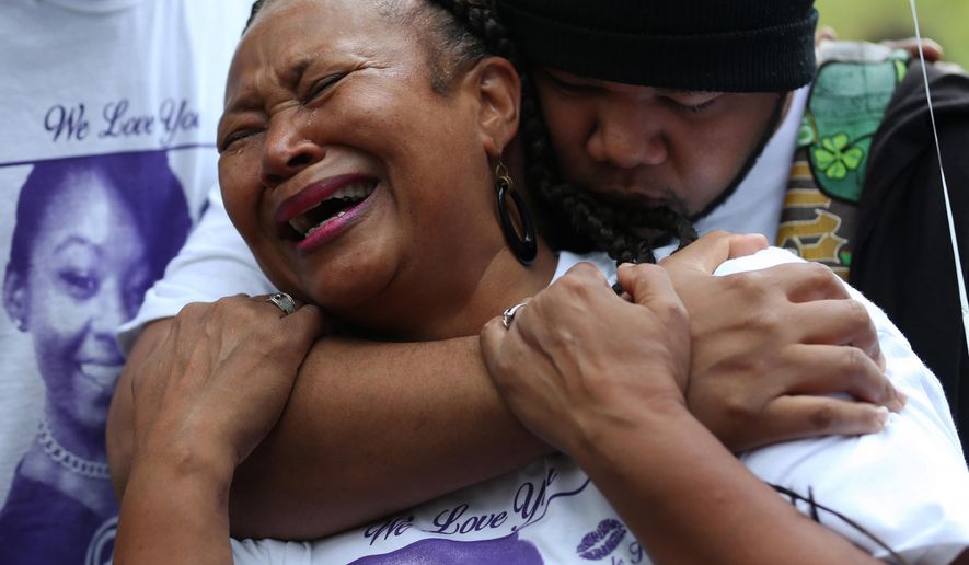 Nia Imani grieves for her daughter Tiara Bogan Jones as her son Robert Bogan comforts her Thursday, Oct. 1, 2015, during a vigil near where the mother of two was shot and killed in Atlanta. She was killed Saturday when shots were fired from another vehicle at an SUV, which hit a tree and flipped over. (Ben Gray/Atlanta Journal-Constitution via AP) MARIETTA DAILY OUT; GWINNETT DAILY POST OUT; LOCAL TELEVISION OUT; WXIA-TV OUT; WGCL-TV OUT; MANDATORY CREDIT
