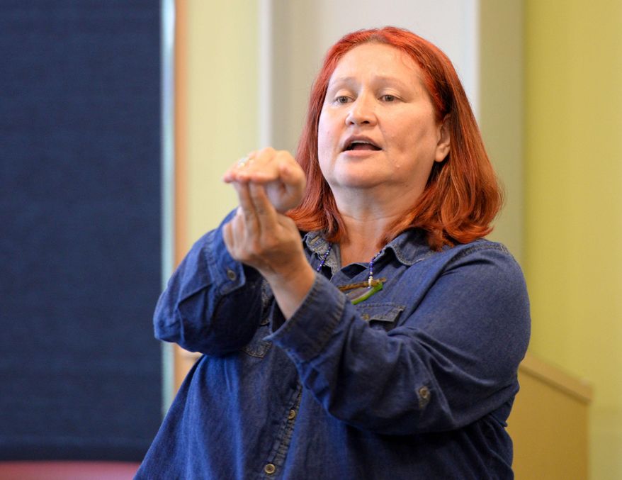 ADVANCE FOR WEEKEND EDITIONS, OCT 3-4 - In this photo taken Aug. 18, 2015, Terri Burr demonstrates how to make a certain sound for the Shm’algyack word for seaweed at the Ketchikan Public Library in Metlakatla, Alaska. John Reese and Terri Burr are two of a number of individuals and organizations working to preserve and revitalize Shm’algyack, as well as Lingít, the Tlingit language, and X_aad Kíl, the Haida language. (Taylor Balkom/Ketchikan Daily News via AP) MANDATORY CREDIT