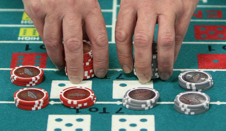 ADVANCE FOR SUNDAY, OCT. 4, 2015 - FILE - In this file photo taken Tuesday, Nov. 27, 2012, at the Horseshoe Casino Cincinnati, one of four casinos authorized by an amendment to Ohio's constitution approved by just over half of voters in November 2009, William Bertke practices stacking chips in preparation for the casino's March 4, 2013, opening. On Tuesday, Nov. 3, 2015, Ohio voters will decide whether to prohibit similar amendments that authorize monopolies, cartels or oligopolies that are commercially beneficial to individuals or private interests, a decision that could cancel out potential approval of an amendment to create a network of 10 authorized marijuana growing facilities, and legalize marijuana for medical reasons and recreational use. (AP Photo/Al Behrman, File)