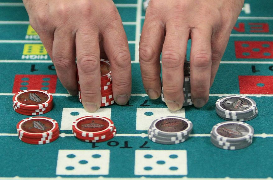 ADVANCE FOR SUNDAY, OCT. 4, 2015 - FILE - In this file photo taken Tuesday, Nov. 27, 2012, at the Horseshoe Casino Cincinnati, one of four casinos authorized by an amendment to Ohio's constitution approved by just over half of voters in November 2009, William Bertke practices stacking chips in preparation for the casino's March 4, 2013, opening. On Tuesday, Nov. 3, 2015, Ohio voters will decide whether to prohibit similar amendments that authorize monopolies, cartels or oligopolies that are commercially beneficial to individuals or private interests, a decision that could cancel out potential approval of an amendment to create a network of 10 authorized marijuana growing facilities, and legalize marijuana for medical reasons and recreational use. (AP Photo/Al Behrman, File)