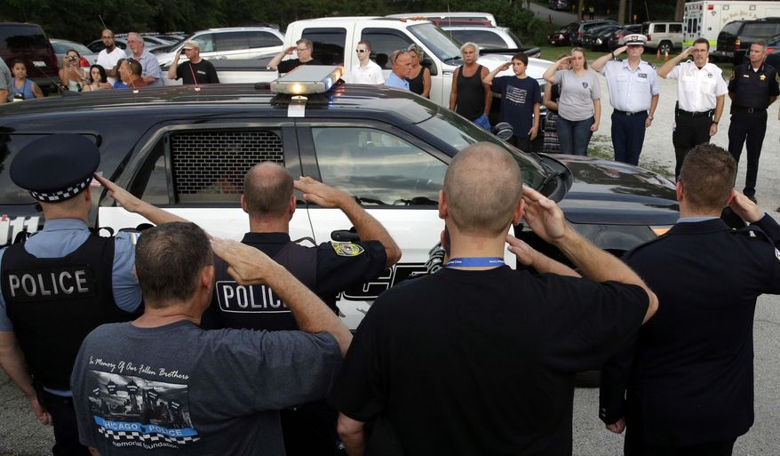 FILE - In this Sept. 2, 2015 file photo, police officers and others salute as the family of slain Fox Lake police officer Lt. Joe Gliniewicz leave after a vigil for him in Fox Lake, Ill. Authorities say 9 unidentified DNA samples were found at the scene where Gliniewicz was found shot to death last month and the killing is still being investigated as a homicide. (AP Photo/Nam Y. Huh, File)