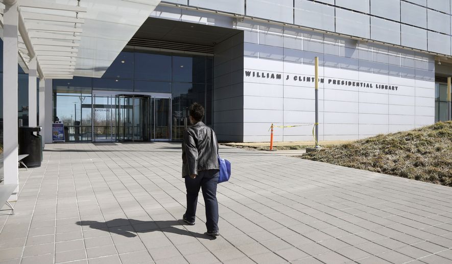 In this photo taken Thursday, March 13, 2014, a woman walks to the Clinton Presidential Library in Little Rock, Ark. The National Archives is scheduled to release thousands of pages of documents from Bill Clinton's administration Friday March 28, 2014. (AP Photo/Danny Johnston)