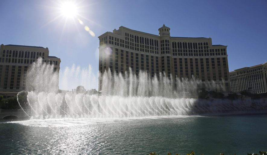 FILE -- In this Aug. 14, 2014 file photo, the sun shines on the fountains of the Bellagio hotel and casino in Las Vegas. Two former craps dealers at the Bellagio and two of their friends have been accused of siphoning more than $1 million off gambling tables over nearly two years by quietly paying phantom bets. (AP Photo/John Locher, File)