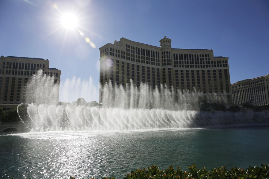 FILE -- In this Aug. 14, 2014 file photo, the sun shines on the fountains of the Bellagio hotel and casino in Las Vegas. Two former craps dealers at the Bellagio and two of their friends have been accused of siphoning more than $1 million off gambling tables over nearly two years by quietly paying phantom bets. (AP Photo/John Locher, File)