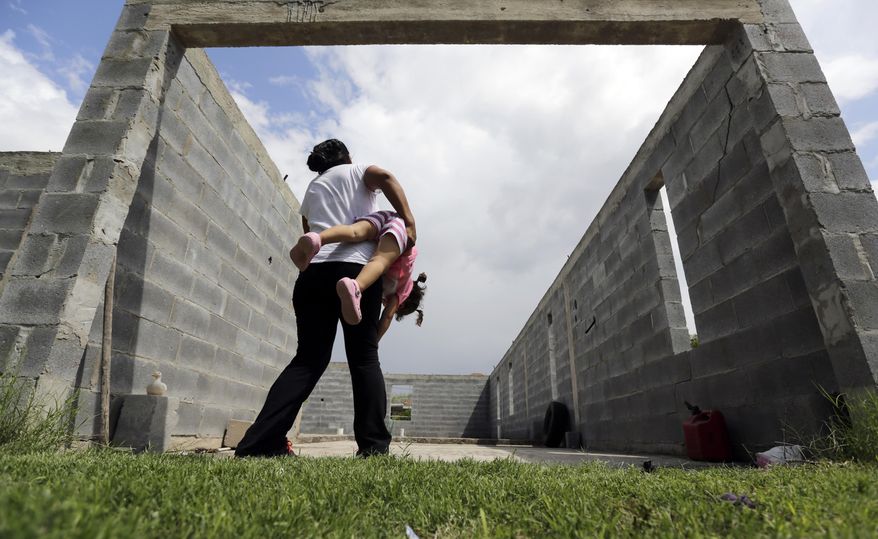 In this Wednesday, Sept. 16, 2015 photo, in Sullivan City, Texas, a woman who is in the country illegally plays with her two-year-old daughter who was born in the in the United States but was denied a birth certificate. Lawyers for immigrant families denied birth certificates for their U.S.-born children by Texas health officials who refuse to recognize as valid certain forms of identification will argue for a federal judge to intervene against the state. (AP Photo/Eric Gay)