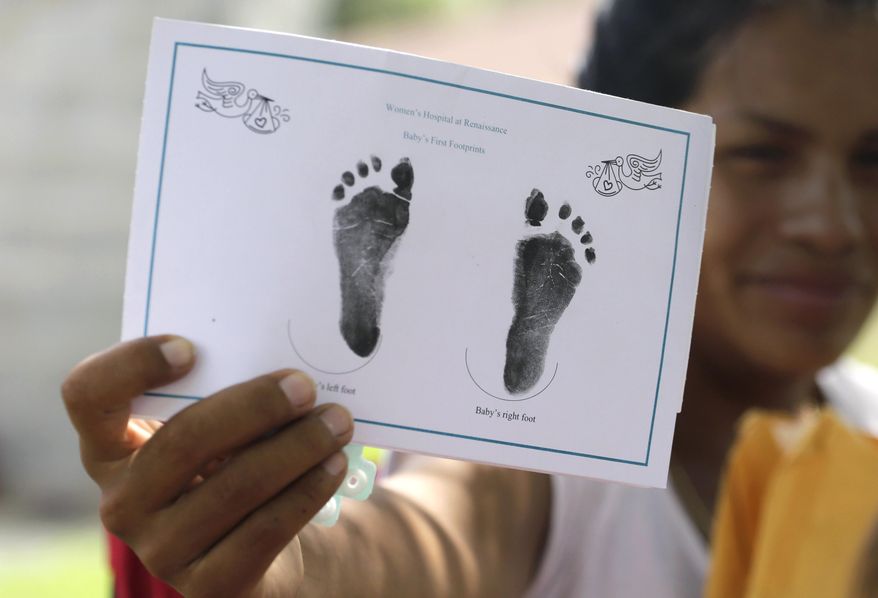 In this Wednesday, Sept. 16, 2015 photo in Sullivan City, Texas, a woman who is in the country illegally shows the footprints of her daughter who was born in the United States but was denied a birth certificate. Lawyers for immigrant families denied birth certificates for their U.S.-born children by Texas health officials who refuse to recognize as valid certain forms of identification will argue for a federal judge to intervene against the state. (AP Photo/Eric Gay)
