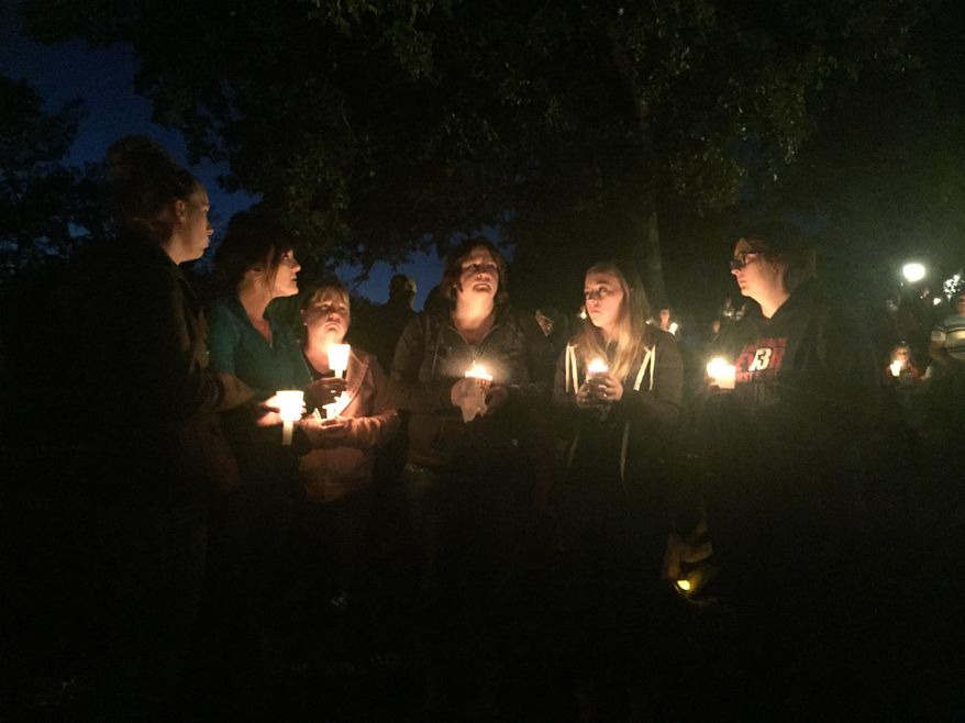 People gather for a candlelight vigil at Stewart Park in Roseburg, Ore., after a shooting with multiple fatalities occurred at Umpqua Community College, Thursday, Oct. 1, 2015. (Dave Killen/The Oregonian via AP)