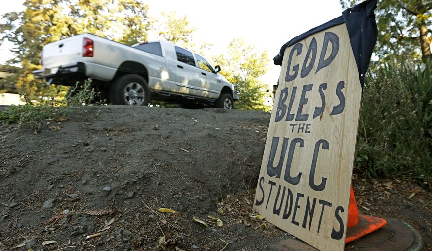A sign honoring those killed in a fatal shooting at Umpqua Community College, is displayed Friday, Oct. 2, 2015, in Roseburg, Ore. Armed with multiple guns, Chris Harper Mercer, walked into a class at the community college, Thursday, and opened fire, killing several and wounding others. (AP Photo/Rich Pedroncelli)
