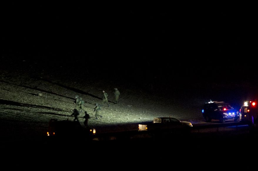 Israeli soldiers search the area of a shooting attack near Nablus, West Bank, Thursday, Oct. 1, 2015. Israeli military said that a Palestinian assailant shot and killed two parents driving with their four children along a West Bank road on Thursday. (AP Photo/Majdi Mohammed)