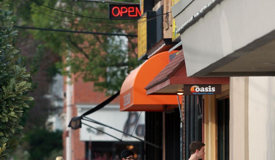 ADVANCE FOR USE SATURDAY, OCT. 3 - In this photo taken, Friday, Sept. 25, 2015, students head to Oasis for a meal on the northside of Iowa City, Iowa. Business owners and Downtown District leaders agree that development at the city's Northside Marketplace has built up the area's vibrancy and atmosphere. (David Scrivner/Iowa City Press-Citizen via AP) NO SALES; MANDATORY CREDIT
