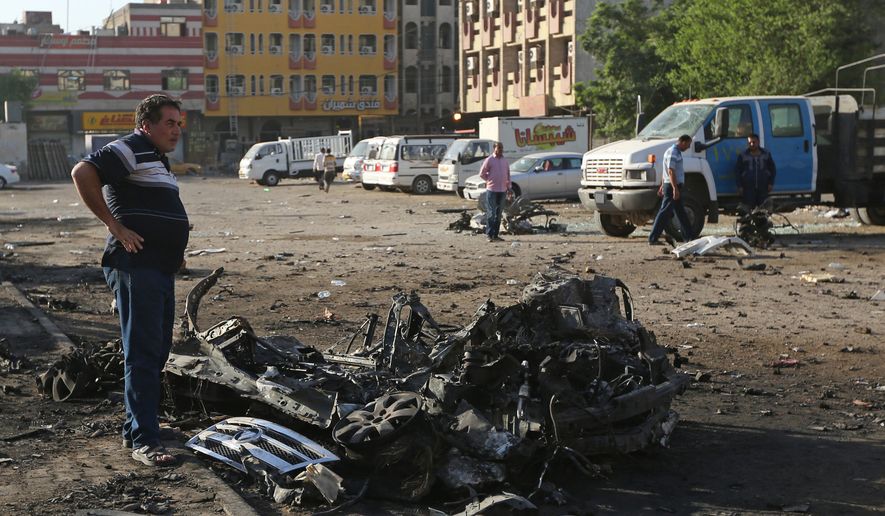 Civilians inspect the aftermath of a car bombing near a restaurant in a commercial area of central Baghdad, Iraq, Tuesday, Sept. 29, 2015. Iraqi officials say a car bomb exploded around midnight Monday in central Baghdad killing and wounding civilians. (AP Photo/Hadi Mizban) ** FILE **