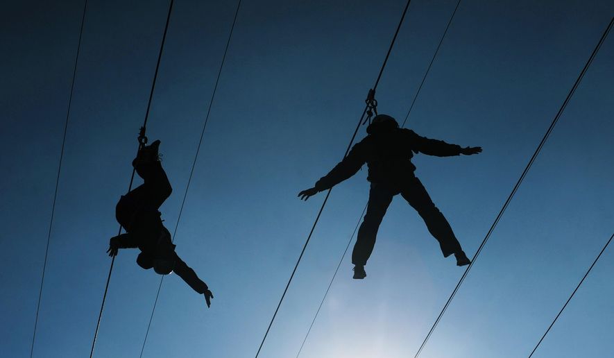 Zip line riders slide above Capitol Street in Indianapolis, in this Feb. 2, 2012, file photo. According to a study published Monday, Oct. 5, 2015, in the American Journal of Emergency Medicine, injuries from zip line accidents have soared along with the popularity of an activity that hurtles riders through the air, sometimes at dizzying heights above ground. (AP Photo/Jeffrey Furticella, File)