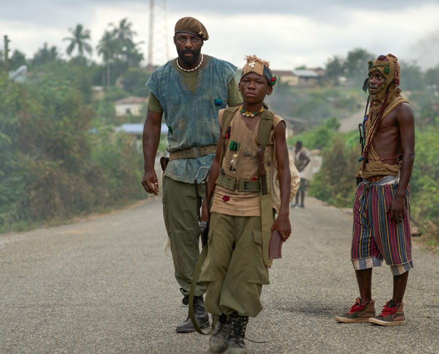 This photo provided by Netflix shows Idris Elba, left, as Commandant, and Abraham Attah, center, as Agu, in the Netflix original film, "Beasts of No Nation," directed by Cary Fukunaga. (Shawn Greene/Netflix via AP)